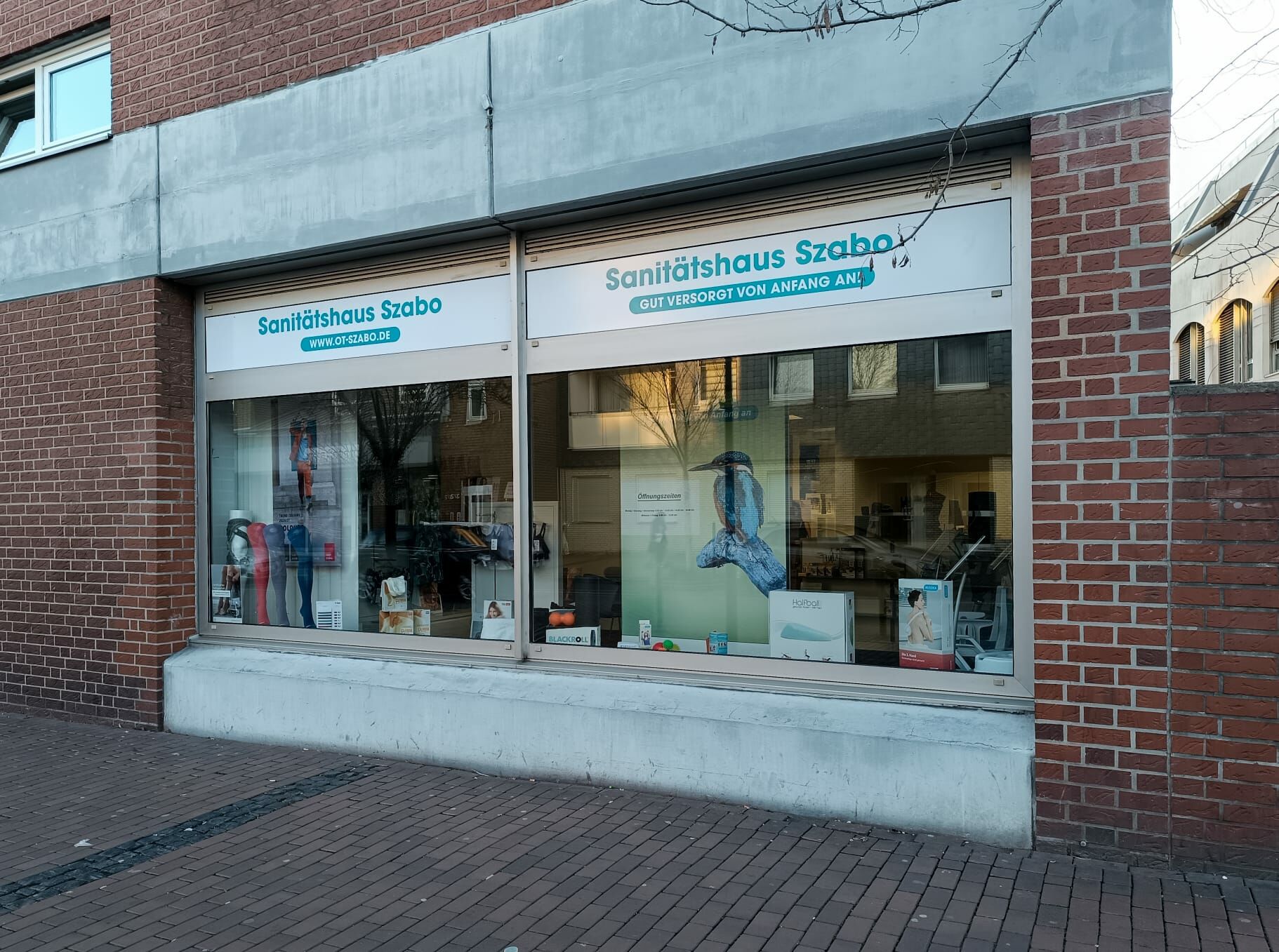 Schaufenster des Sanitätshauses Szabo mit Produkten und Beschriftung an der Straße.